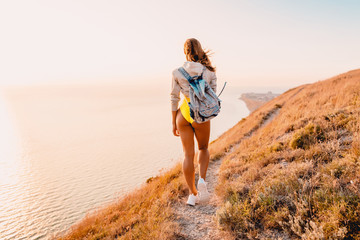 Young fitness woman in yellow clothes and in white sneakers in nature.