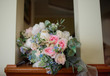 Rich wedding bouquet made of white, pink and blue flowers stands in the room