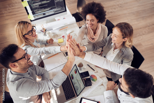 Cuadros en Lienzo Happy business team giving high five in office
