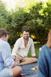 © Scandinav - Smiling bearded man sitting with friends at picnic