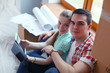 © lenets_tan - Couple moving in house sitting on the floor with ipad. Couple