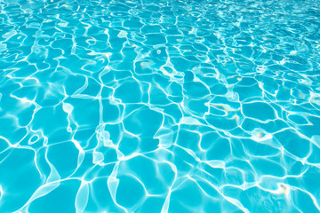 blue and bright water surface and ripple wave with sun reflection in swimming pool