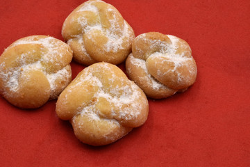 Close up of traditional Italian cookies or biscuits with knot shape on red background and copy space.