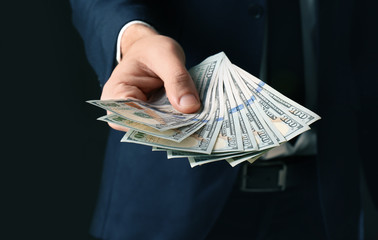 Poster - Businessman holding bribe on black background