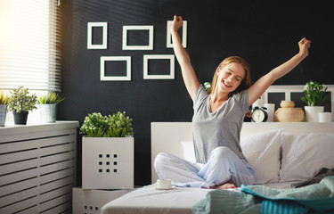 Wall Mural - young   woman woke up in the morning in the bedroom by the window with her back