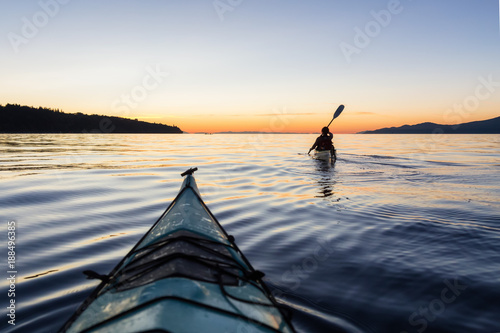 Fotomural Adventure Woman Kayaking on a Sea Kayak during a Vibrant Sunset