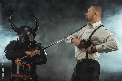 Fotografia, Obraz armored samurai with katana ready to kill man while he taking out his gun