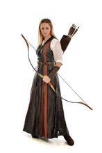 Full Length Portrait Of Girl Wearing Brown  Fantasy Costume, Holding A Bow And Arrow. Standing Pose On White Studio Background. 