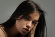 Model. Attractive serious long-haired young woman staring and touching her face and having her mouth half opened