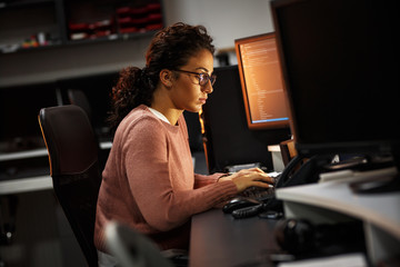 female programmer working on new project.she working late at night in her office.