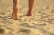 barefoot girl walking on the sand beach with sunset light