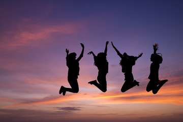 Silhouette of young people jumping together,friend having fun,happy friends with sunset background.Friendship Day,unity and freedom concept.