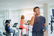 © Vittaya_25 - muscular asian young handsome man wipes sweat with towel and drinking water while resting after workout for good healthy with people in fitness gym, bodybuilder, lifestyle and sport exercise concept