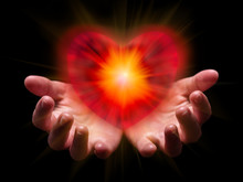 Hands Cupped And Holding Or Showing Romantic Red Heart For Valentine Or Valentines Day With Bright, Glowing, Shining Light. Concept For Offering, Giving In Love, Passion, Romance. Black Background