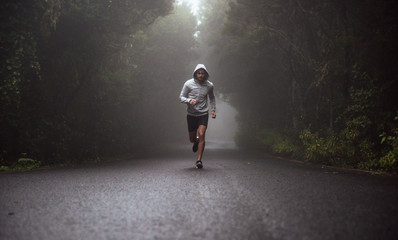 portrait of a young athlete running on the road