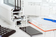 © Youril - Work space table with notepad, pen, tape measure, calculator, sample of triple glazed and pvc window cut on white background. Top view, Flat lay.