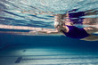 © LIGHTFIELD STUDIOS - underwater picture of young female swimmer exercising in swimming pool