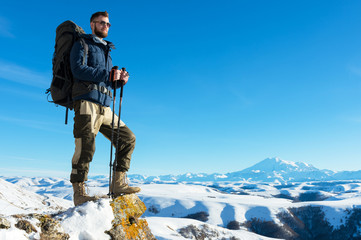 A hipster traveler with a beard wearing sunglasses in nature.