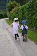 Schwester hilft ihrem Bruder beim Radfahren