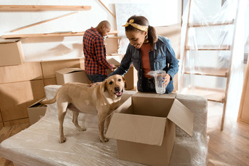 african american couple with labrador dog moving to new home