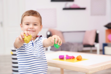 Canvas Print - Cute little boy modeling from playdough at home