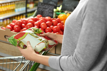 Sticker - Young woman with fresh lettuce in supermarket