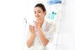 © Africa Studio - Attractive young woman applying face cream in bathroom