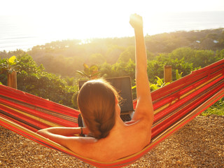 digital nomad girl working in the hammock