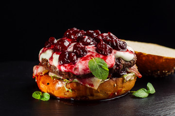 Burger, hamburger sandwich with cutlet of minced meat, cheese brie, camembert, berry cherry.