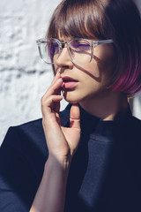 Wall Mural - beautiful stylish woman with pink hair and glasses touching lips with hand