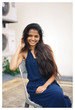 © Danon - Portrait of young Indian Asian woman sitting on a chair in the middle of the street and smiling at the camera.