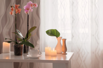 Poster - orchids, cup, candles on the table in the room