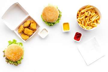 Fast food. Chiken nuggets, burgers and french fries on white background top view space for text