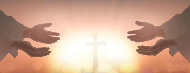 Resurrection of Easter Sunday concept: Silhouette two humans open spiritual hands over blurred cross sunset background.