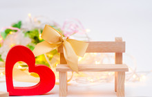 Wooden Heart With A Bow On A Bench On A White Background. Valentine's Day