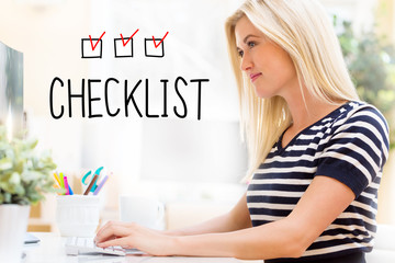 Wall Mural - Checklist with happy young woman sitting at her desk in front of the computer