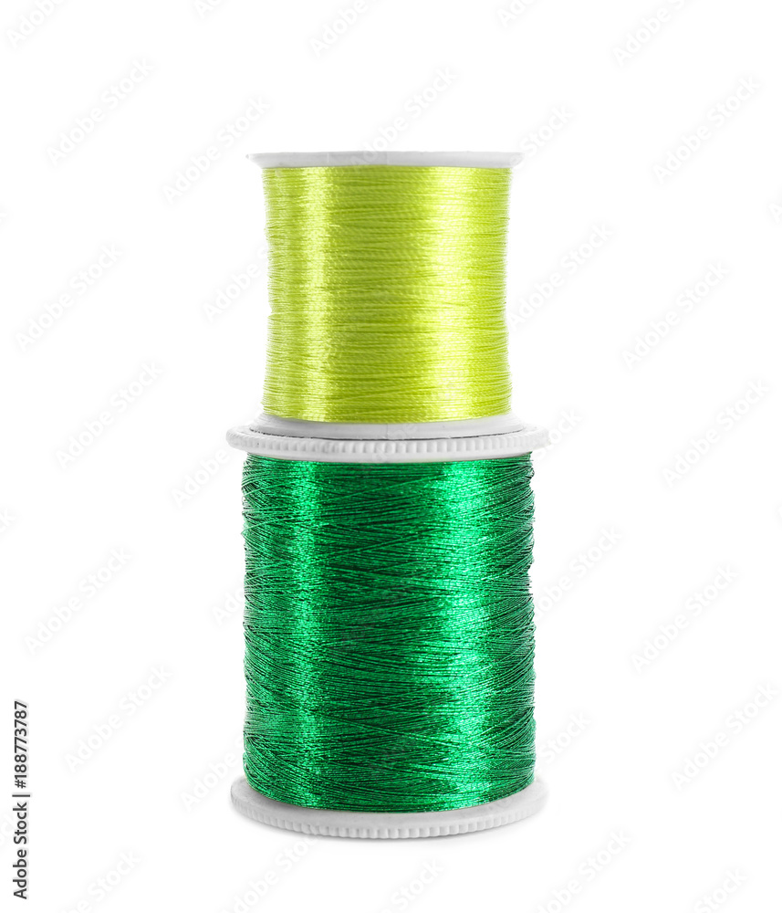 Green sewing threads on white background