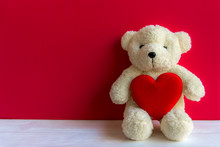 Cute Teddy Bear With Red Heart On Old Wood, Copy Space, Red Background. Valentine Concept.