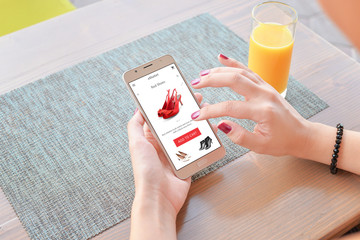 Poster - Woman buy red shoes online . Mobile app or web site on screen. Table and juice in background.