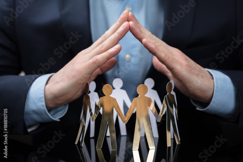 Fotografía Businessperson Protecting Paper Cut Out People