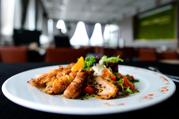 Poster - Delicious juicy roasted meat with spices and tomato in a white plate in a cafe, shallow dof