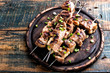 Grilled meat skewers, shish kebab on wooden background, top view
