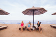 © F8  \ Suport Ukraine - Portrait of three women friends sitting and resting in lounge chairs with umbrella on the sea beach. Summer vocation.