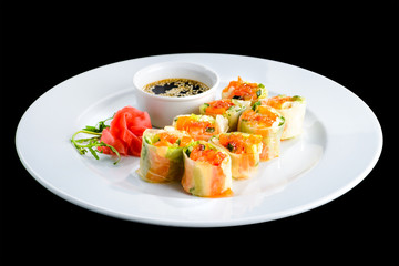 Wall Mural - fresh vegetable spring rolls with soy sauce and ginger in a white plate, isolated on black backgroun