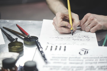 Master calligraphy writing. Hand with pen closeup