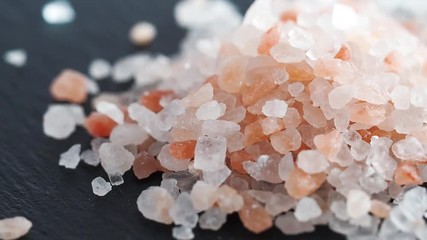 Wall Mural - Pile of pink himalayan rock salt isolated on black. Rotation