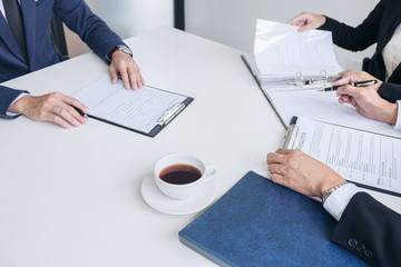 Wall Mural - Interviewer or Board reading a resume during a job interview, Employer interviewing a young male job seeker for recruitment talking in modern office, employment and recruitment concept