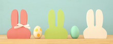 Cute Colorful Wooden Bunny Ears And Easter Eggs Over Wooden Table.