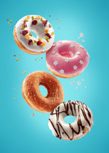 Donuts Selection Flying On Blue Background. Various Doughnuts Isolated On Colorful Background