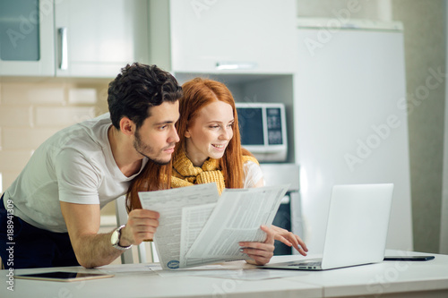 Fotografía cheerful young couple calculating their bills at home